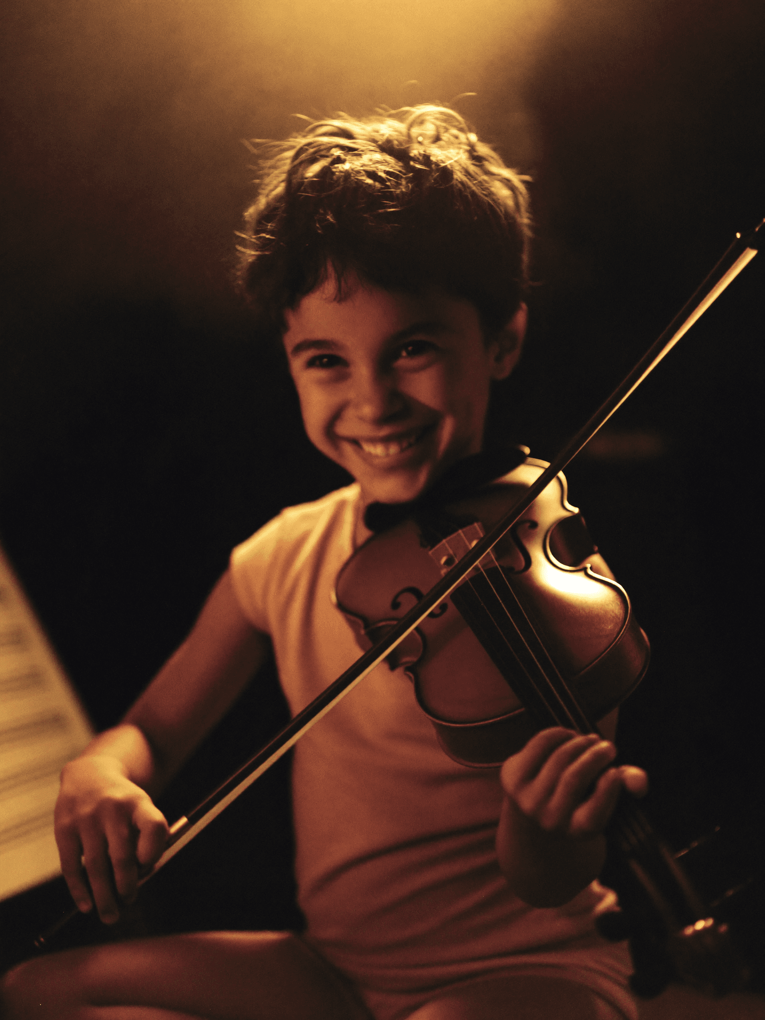 Niña sosteniendo un violín durante su clase