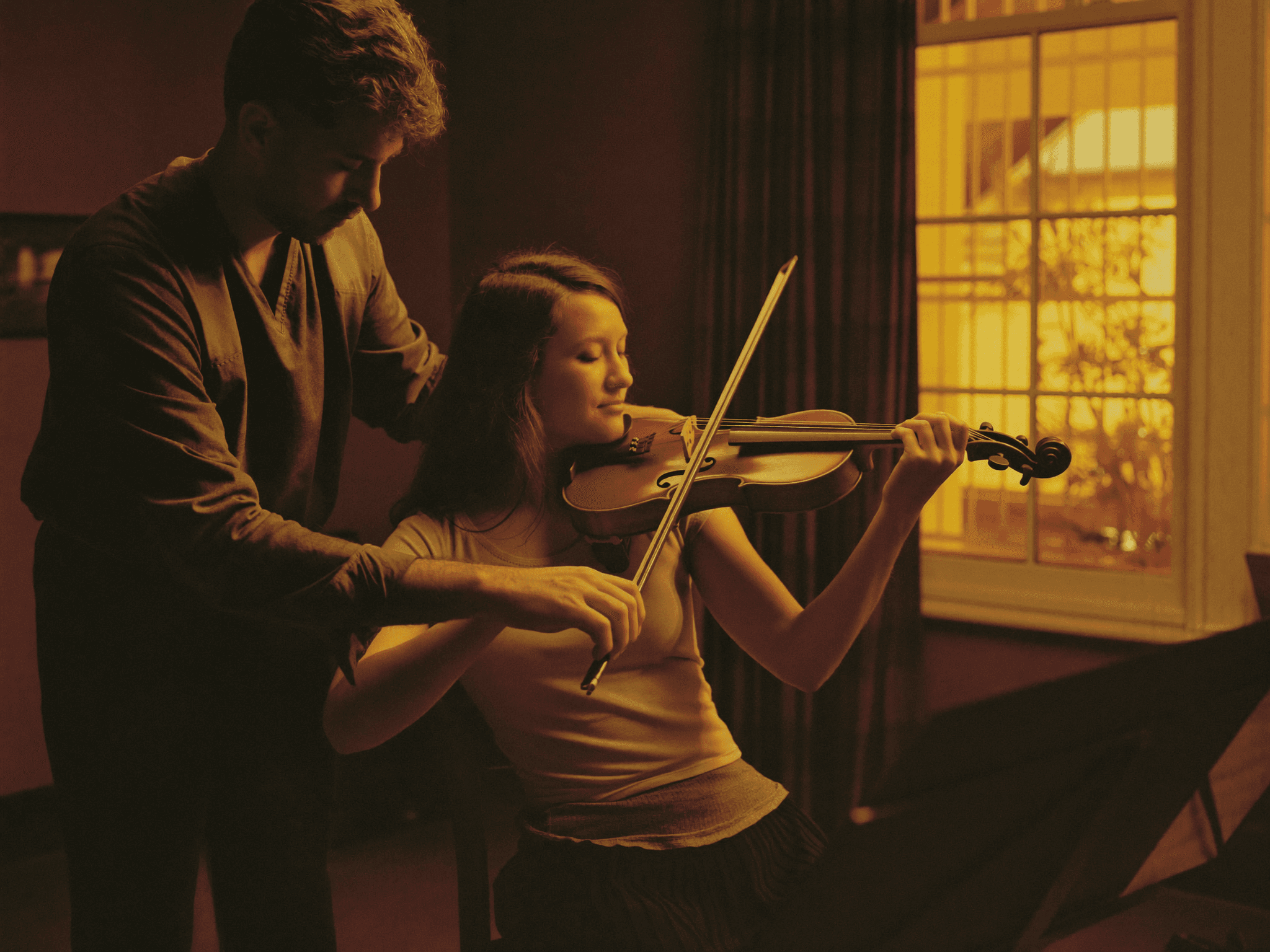 Alumno adulto practicando violín en clase